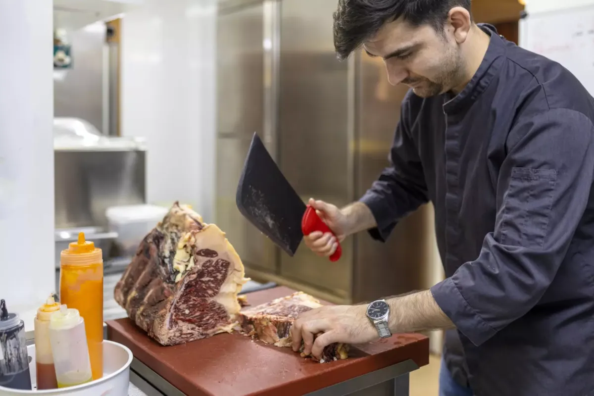 Hombre cortando chuletón